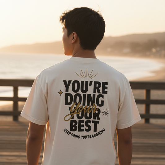 Beige t-shirt with motivational text on the back against a white background